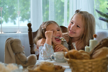 Rustic afternoon: Little siblings bond over an English tea session in a cozy village home - obrazy, fototapety, plakaty