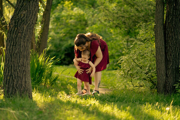 Surrounded by the warmth of the day and the cool shelter of trees, a child reaches for the sky,...