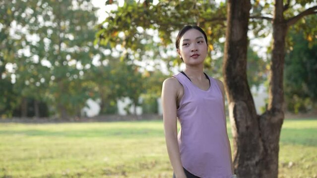 Beautiful Asian woman doing fitness exercises, stretching before or after exercise at outdoor nature park, lifestyle, sports, fitness for good health.