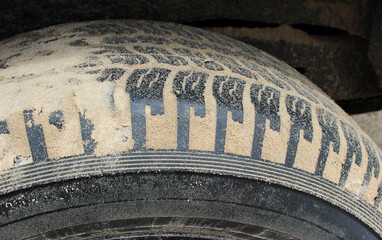 Dirty car tire treads clogged with sand side view detailed stock photo