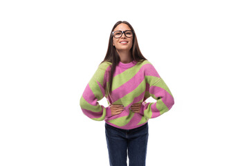 young beautiful caucasian woman with straight black hair with glasses is dressed in a stylish autumn striped pullover on a white background