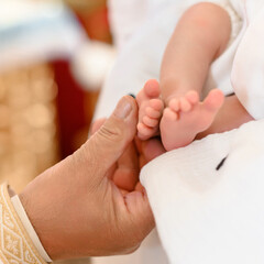 The priest performs the rite of baptism of the child and anoints the leg with holy peace.