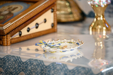 A golden cross lies on a tray in the church, candles are nearby, Christian rites in the church.