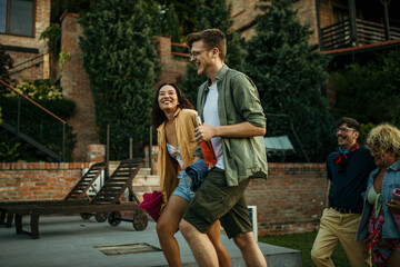 Friends from different backgrounds walk happily to a pool party, bringing diverse vibes