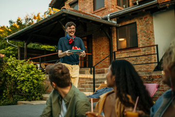 Multicultural friends laughing, sharing stories, and relishing fruits and cocktails in a sunny setting