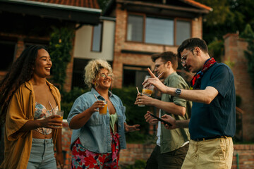 Diverse friends enjoy backyard vibes: laughing, chatting, and sipping drinks at a lively party