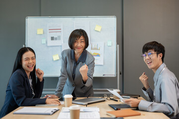 Group of cheerful Asian businesspeople are celebrating their project success in the meeting together