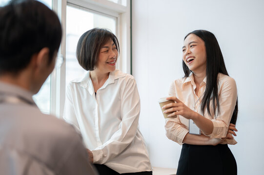 Group of happy diverse Asian businesspeople colleagues are enjoying talking during a coffee break.