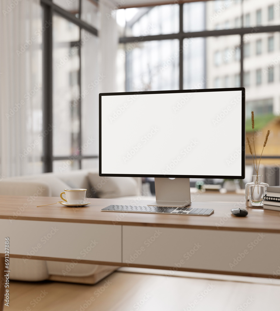 Poster an empty pc computer screen mockup on a wooden desk in a modern room with large glass window wall.