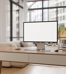An empty PC computer screen mockup on a wooden desk in a modern room with large glass window wall.