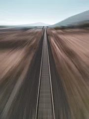 Poster Treinspoor Motion blur view taken by drone of train track passing through arid land