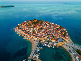 Primosten, Croatia - Aerial view of Primosten peninsula, St. George's Church and old town on sunny summer morning in Dalmatia, Croatia. Yacht marina and turquoise sea water at sunrise the Adriatic sea