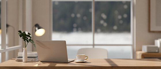 Minimalist Scandinavian office workspace with a laptop computer on a wooden table. close-up image