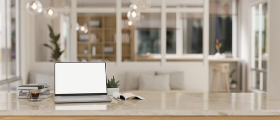 A white-screen laptop computer mockup on a desk in a modern beautiful living room.