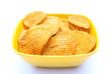 Potatoes chips in a yellow bowl on white background close-up view 