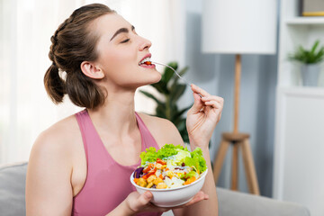 Healthy sporty and vegetarian woman in sportswear with a bowl of fruit and vegetable. Healthy cuisine nutrition and vegan lifestyle for fitness body physique at gaiety home concept.