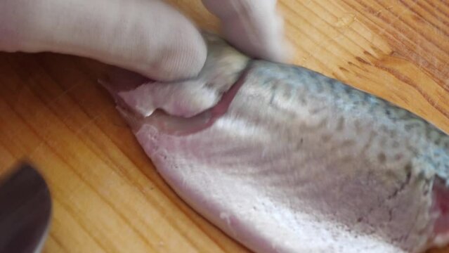 칼로 고등어 살을 발라 한점 한점 회를 떠서 접시에 담는 모습