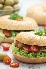 Sesame bagels with tomatoes, ham and olives	