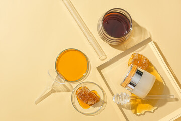 View from above of a cosmetic jar with a luxurious design and honey stored in glassware on a beige background. Natural cosmetics with honey extract.