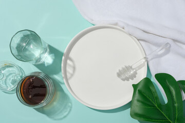 Top view of a white ceramic plate, honey, glass of water and props on display. Honey helps protect...