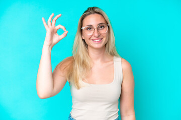 Fototapeta premium Young caucasian woman isolated on blue background With glasses and doing OK sign