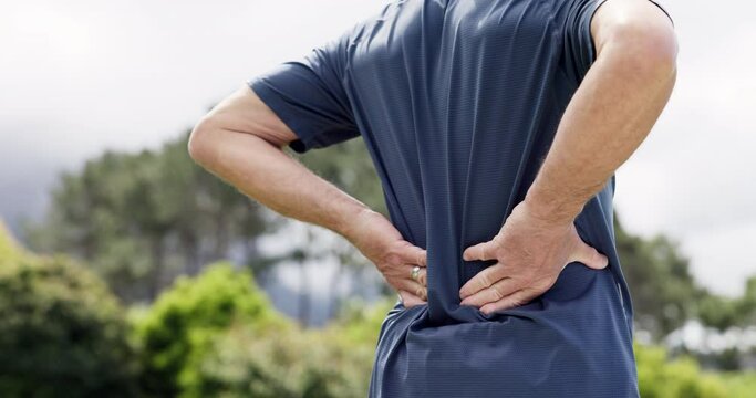 Senior man, back pain and injury from fitness, outdoor and hands for arthritis, osteoporosis and park. Health issue, retired or sick with bone, healthcare and ache for muscle tension, strain or hurt