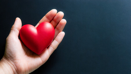 Fototapeta premium Hand holding a heart symbol, copy space on a side