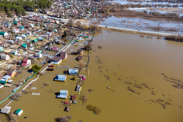 Heavy spring flood of the river with water reaching dacha plots located in the lowlands