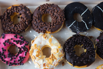 Delicious dessert. Pink, white, almond and chocolate donuts with colorful sprinkles