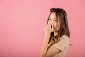 Foto op Canvas Asian beautiful young woman unhappy what a smell disgust expression squeezing nose with fingers. Female have something stinks bad smell situation, studio shot isolated on pink background, Healthcare © sorapop