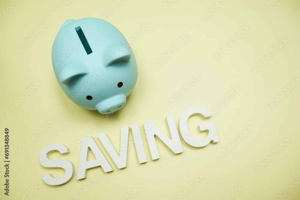 Poster saving alphabet letters and piggy bank top view on yellow background