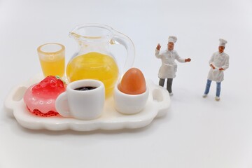miniature figurines of cooks with a breakfast served on a tray