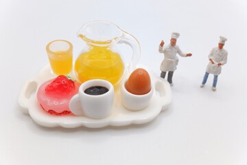 miniature figurines of cooks with a breakfast served on a tray