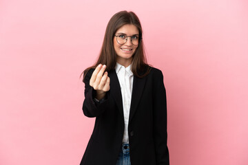 Young Business caucasian woman isolated on pink background making money gesture