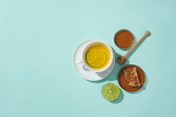 Close-up of a cup of lemon-honey tea against a blue background. In foods, honey is used as a natural sweetener. Free space for natural food advertising. Copy space.