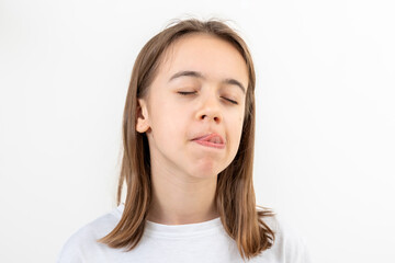 Fototapeta premium Funny teenage girl licks her lips on a white background isolated.
