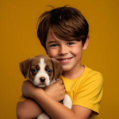 Boy hugging a puppy on yellow background.
