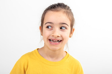 Little girl looks to the side in surprise on a white background isolated.