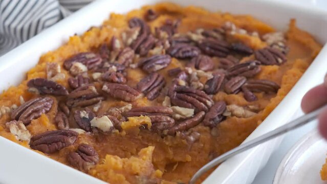 Traditional sweet potato casserole with pecan, white background, close-up. Holiday recipe recipe.