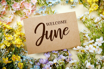 Welcome June text message with flower decoration on yellow background - obrazy, fototapety, plakaty