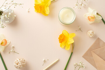 Celebrate the season of spring with a heartfelt greeting. Top view picture displays daffodils, gypsophila, an envelope and aroma candle on a beige isolated background, ready for adverts or text