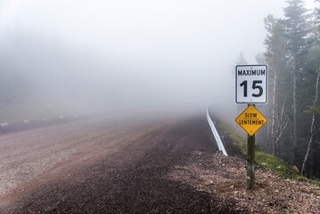 Slow Lentement sign Warning yellow roads signs road in Background foggy Cape Breton Island Nova...