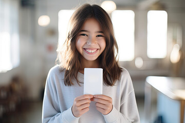 Young business woman holding a blank card, radiating happiness and professionalism.