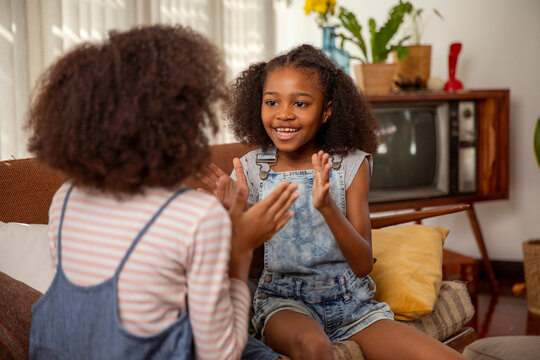 Girls playing clapping game at home