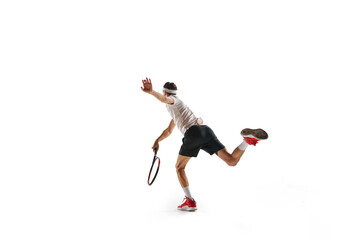 Fototapeta na wymiar Concentered young man, tennis payer in motion during game, training, hitting ball with racket isolated over white background. Concept of sport, hobby, active and healthy lifestyle, competition
