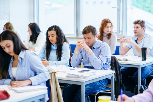 Multi-ethnic students studying at desk in classroom