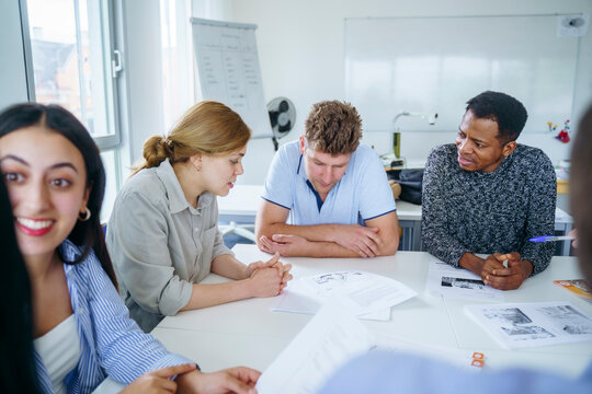 Multi-ethnic friends studying together at desk in education training class