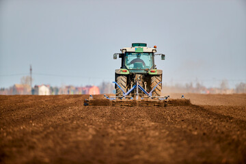 Tractor plowing field in early spring