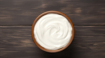 Bowl of tasty sour cream on wooden table