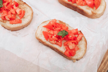 Delicious bruschetta, toasted bread with tomatoes on white paper